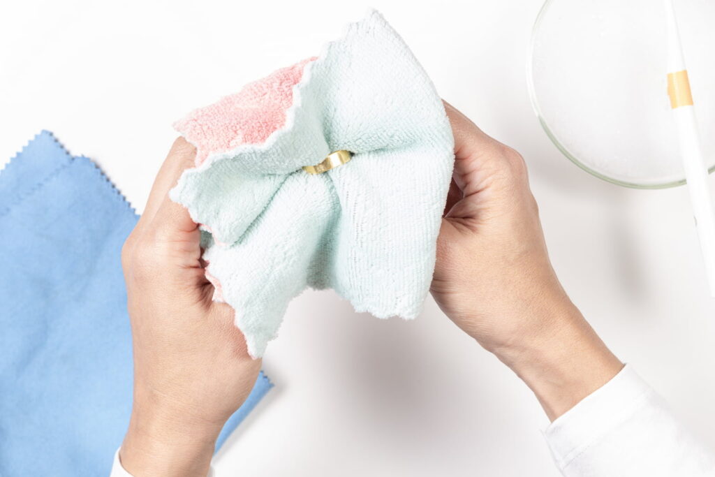 มือผู้หญิงกำลังใช้วิธีล้างทองให้เหมือนใหม่