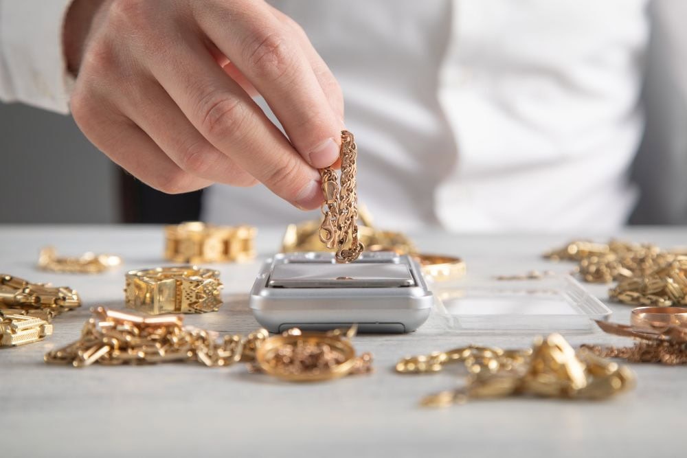 ร้านขายทองกำลังชั่งทองคำเพื่อตรวจสอบน้ำหนัก เพื่อเปรียบเทียบราคาว่าการจำนำทองกับขายทองราคาต่างกันไหม